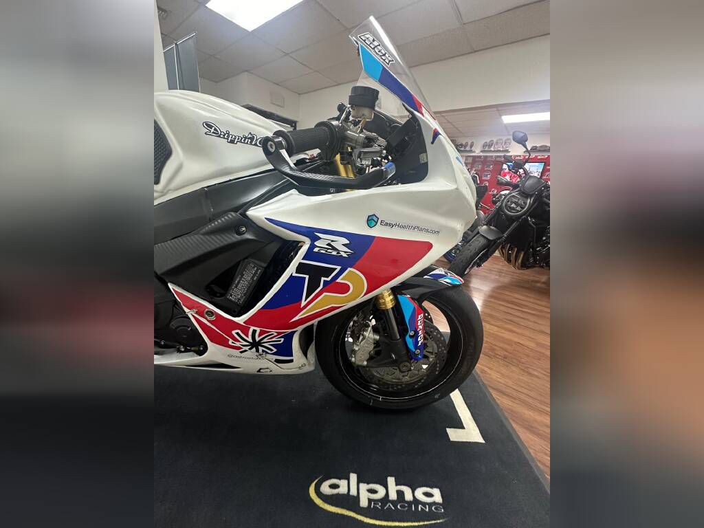 A row of high-performance sport bikes inside Top Pro Motorsports shop, lined up next to a dyno machine.