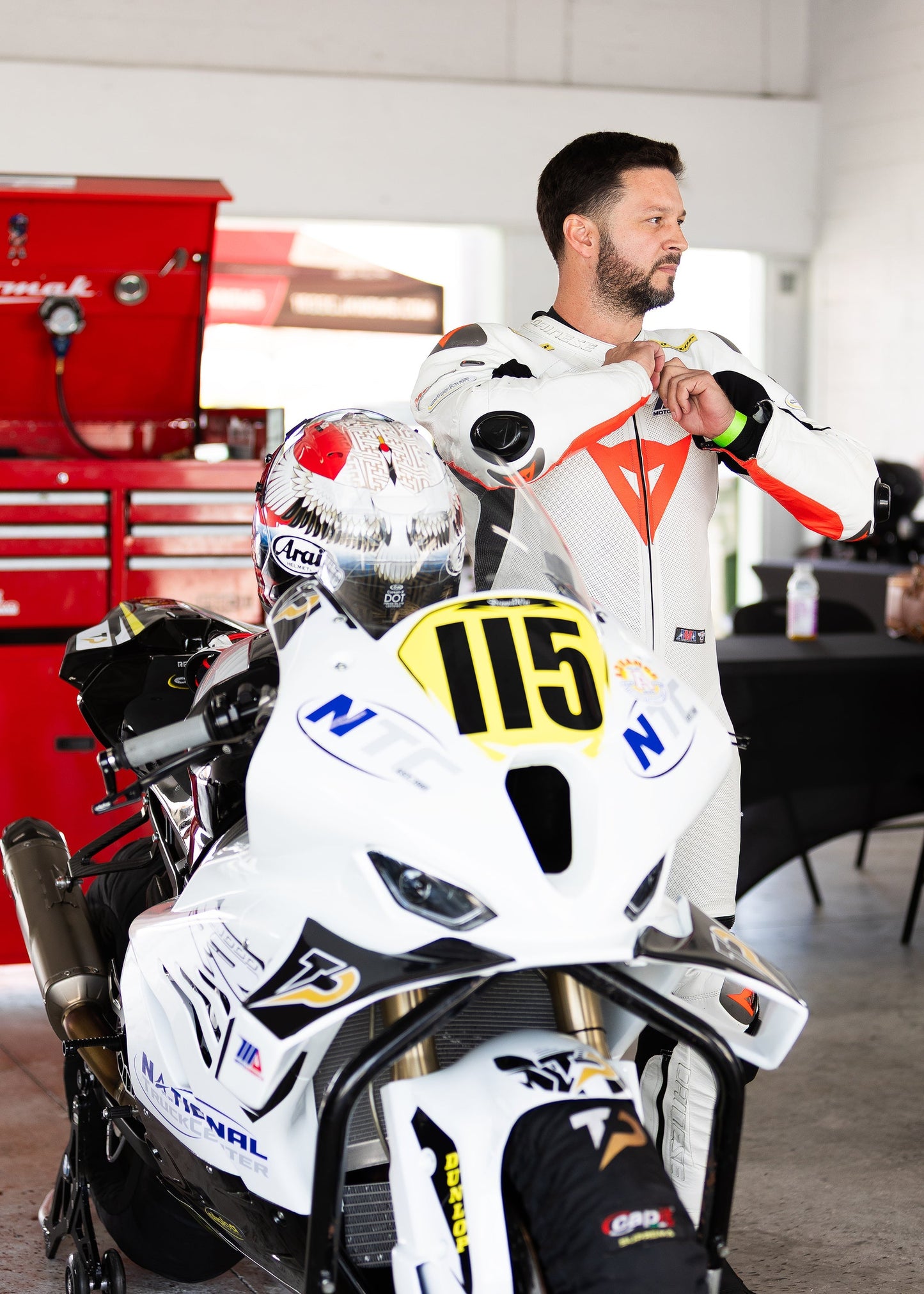Motorcycle rider in full race gear leans into a turn at Homestead-Miami Speedway during a track day in South Florida