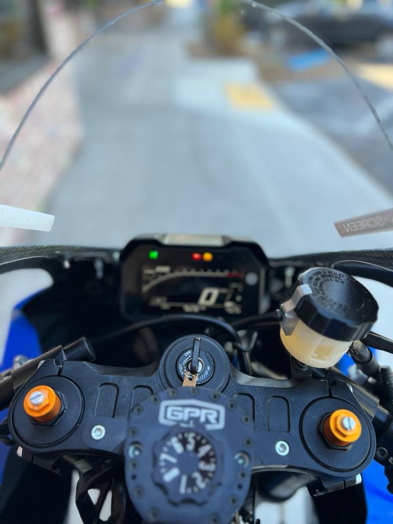 Motorcycle technician performing a brake inspection at Top Pro Motorsports in Coral Springs, FL