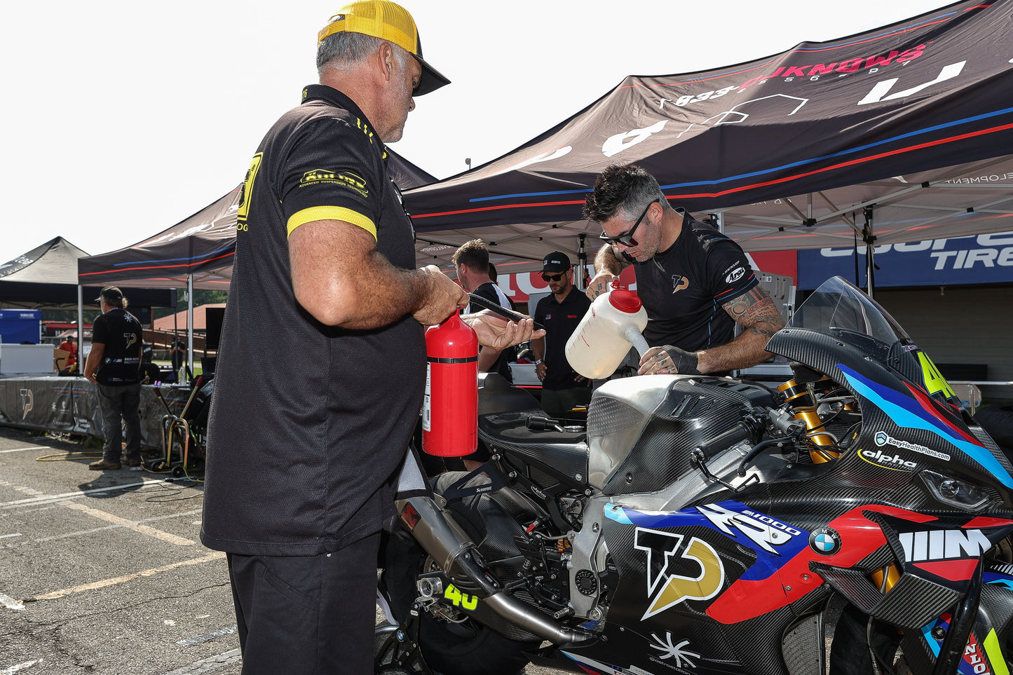 Motorcycle rider geared up and ready to ride on a race track in South Florida, with a support crew from Top Pro Motorsports.