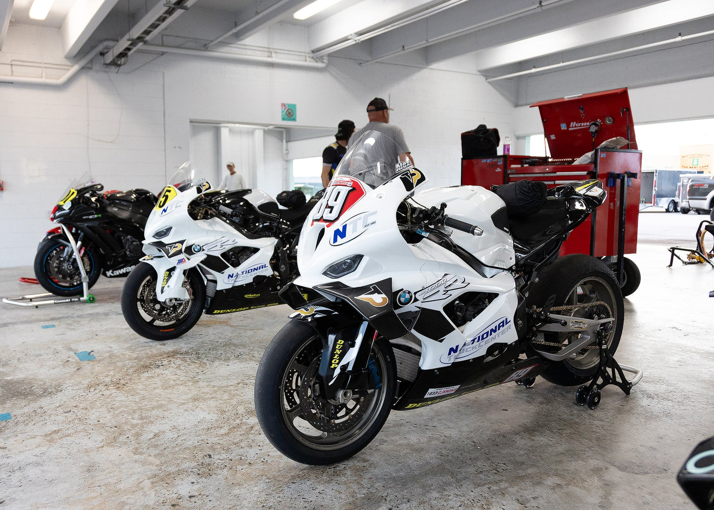 Motorcycle maintenance technician checking tire pressure in Coconut Creek.