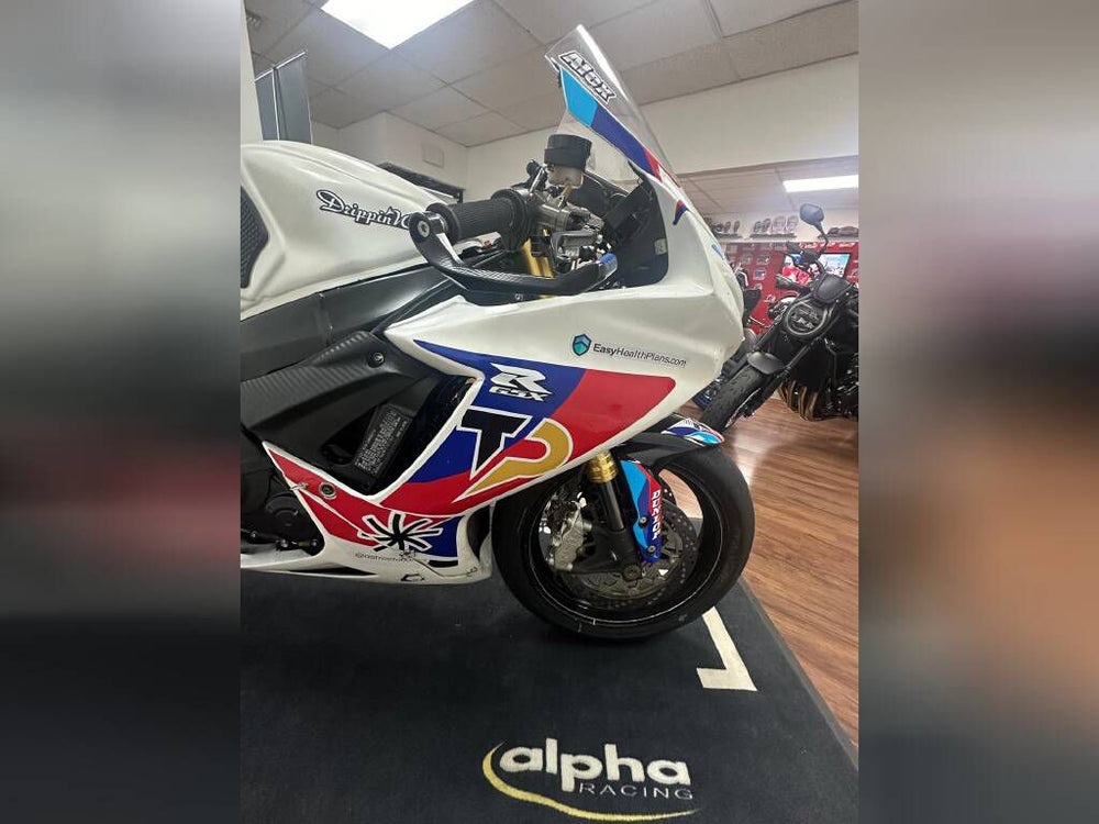 A row of high-performance sport bikes inside Top Pro Motorsports shop, lined up next to a dyno machine.