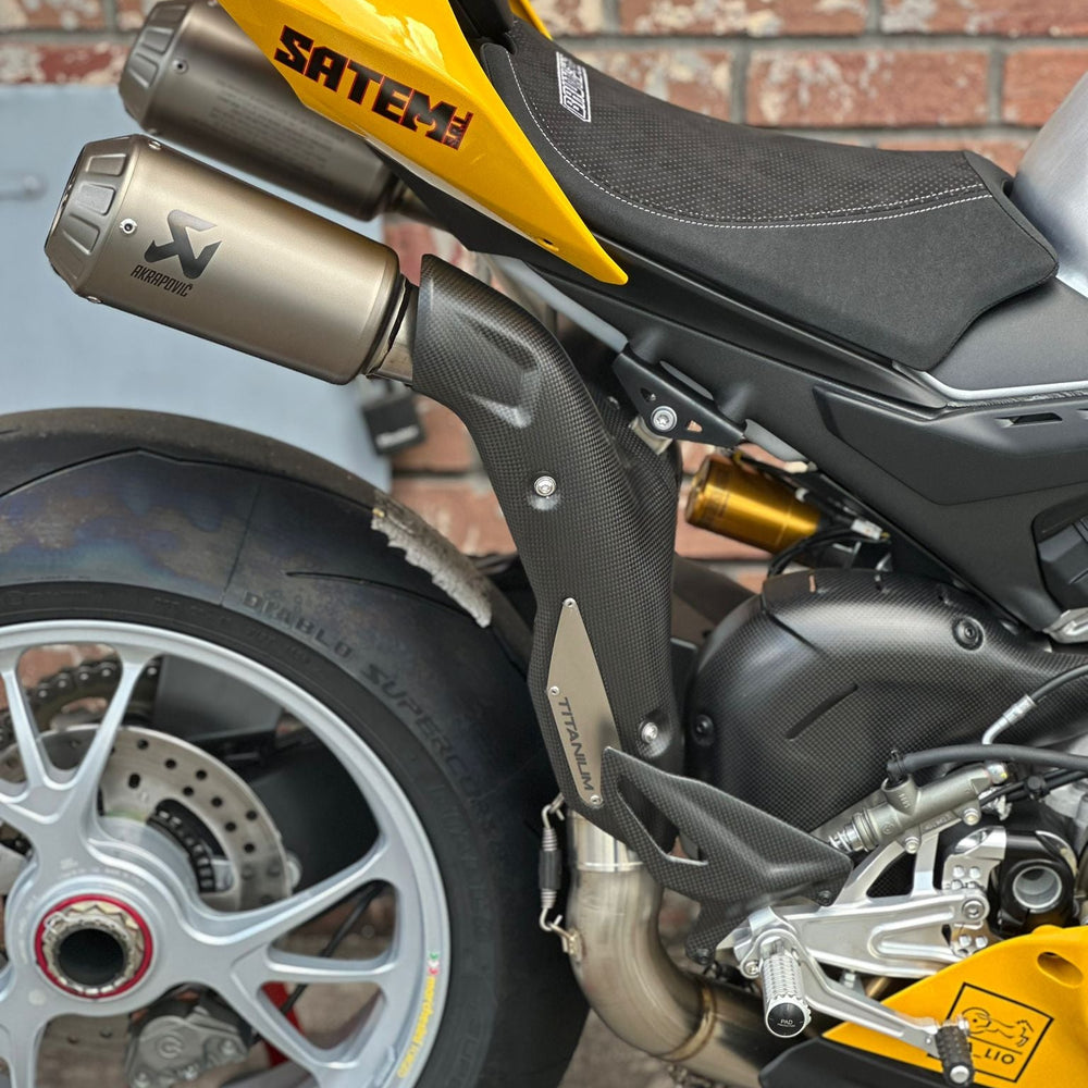Motorcycle exhaust pipe with visible flames from popping