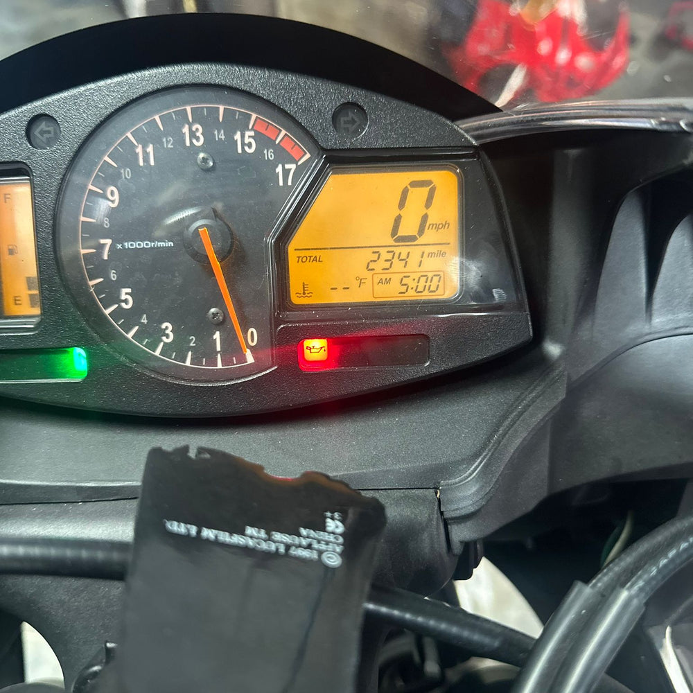 Motorcycle mechanic in Coconut Creek performing maintenance on a custom sportbike at Top Pro Motorsports, with tools and diagnostic equipment visible.