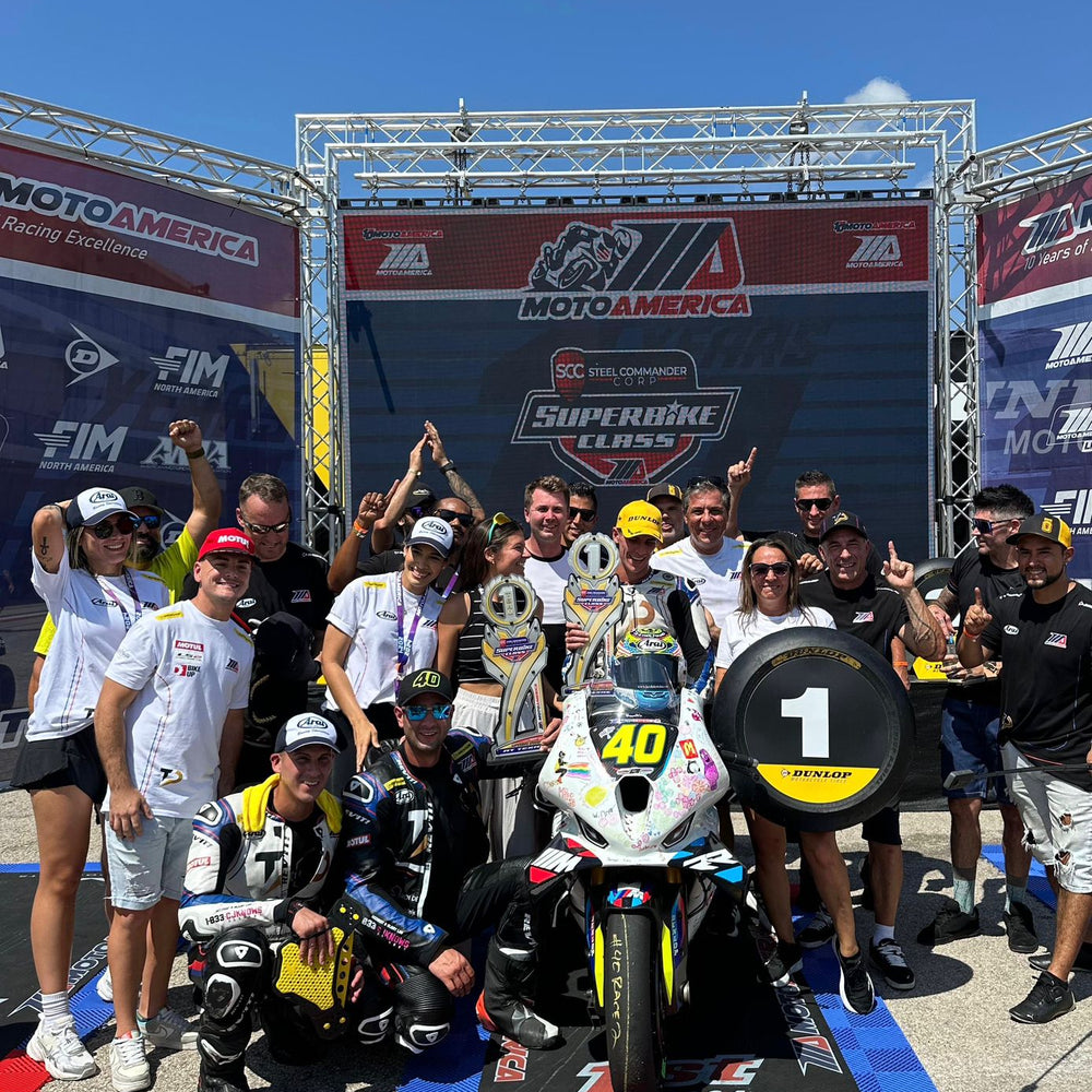 Motorcycle riders in full racing gear taking off from the starting line during a South Florida track day.