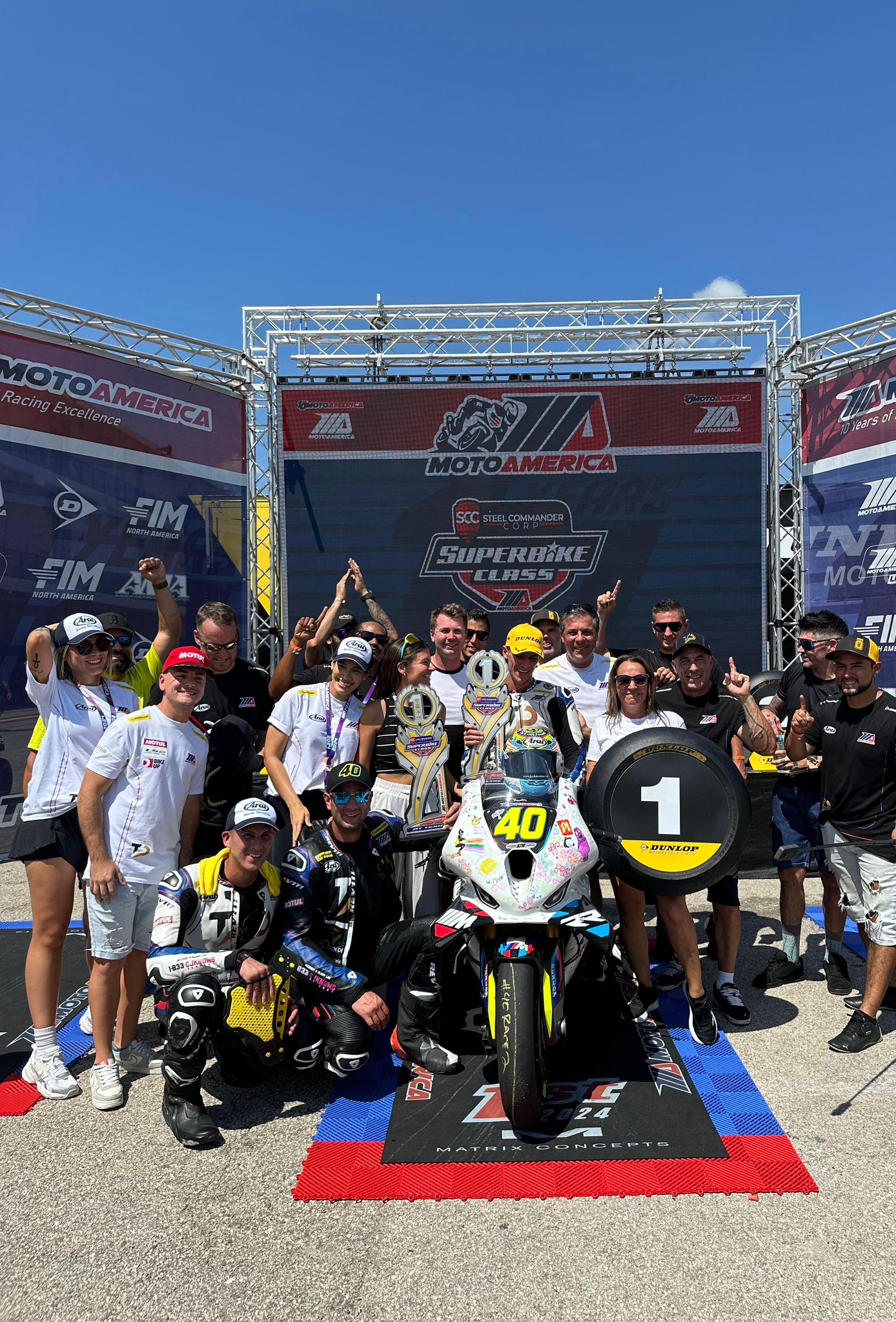 Motorcycle riders in full racing gear taking off from the starting line during a South Florida track day.